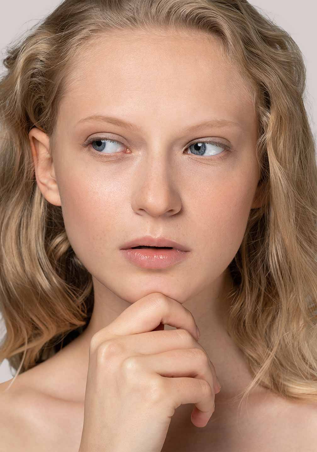 Frau mit blonden Wellenhaaren präsentiert RAU Cosmetics BB Cream Perfect Care Light für helle Hauttypen.