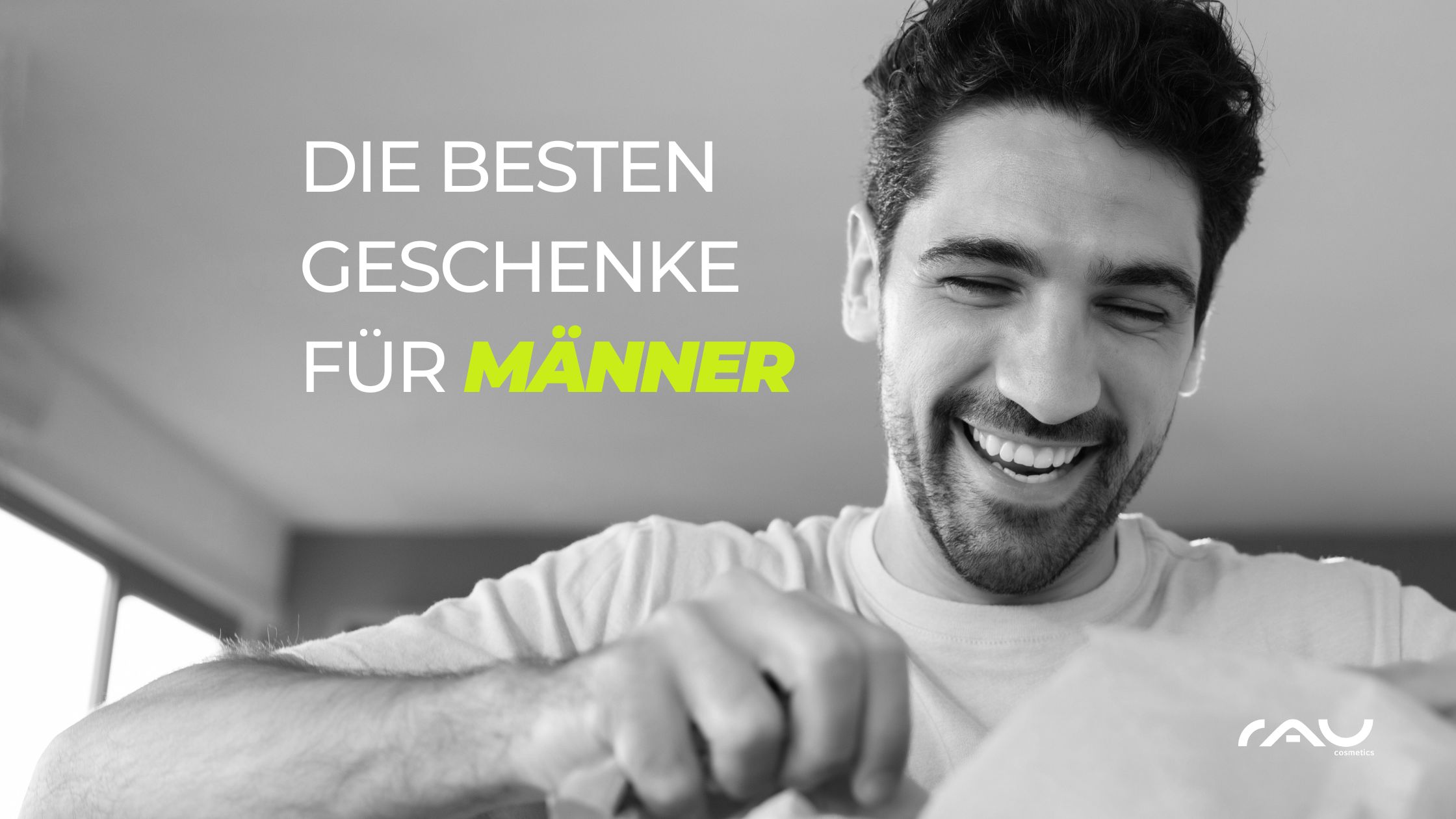 Die besten Geschenk fr Mnner_Valentinstag (1) Lächelnder Mann öffnet ein Geschenk, umgeben von der Aufschrift "Die besten Geschenke für Männer" in einem modernen, hellen Raum, passend zu Valentinstag Geschenkideen von RAU Cosmetics.